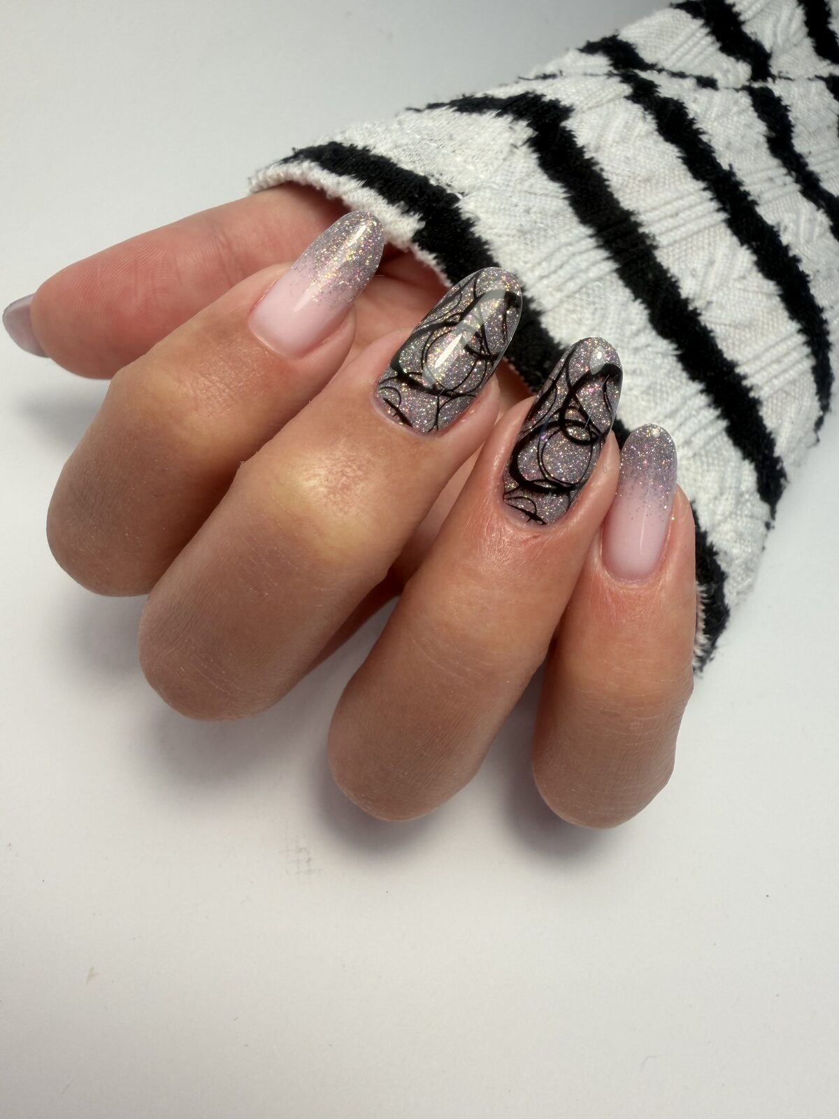 Strieborný glitrový nail art s jemnou čiernou kresbou